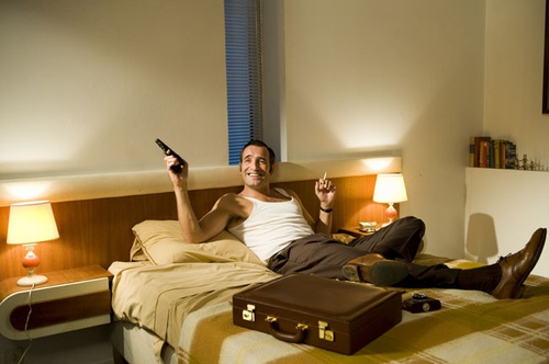 Jean Dujardin allongé sur le lit