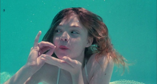 Elle Fanning fait semblant de boire dans la piscine